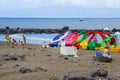 Holiday makers enjoy the welcome relief of an overcast sky as the sunbath on the sandy beach at Playa Las Americas in Teneriffe in