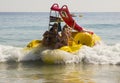 Holiday makers in hired Pedalos fight against the incoming surf to get out into calmer water at the beach in Albuferia Portugal Royalty Free Stock Photo