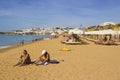 Holiday makers relaxing in the sun on the Praia Azul beach in Albuferia, Portugal Royalty Free Stock Photo