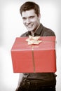 Holiday. Man giving gift box with golden ribbon Royalty Free Stock Photo