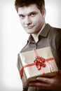 Holiday. Man giving golden gift box with ribbon Royalty Free Stock Photo