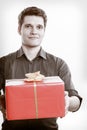 Holiday. Man giving red gift box with golden ribbon Royalty Free Stock Photo