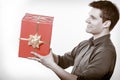 Holiday. Man giving red gift box with golden ribbon Royalty Free Stock Photo