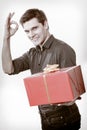 Holiday. Man giving red gift box showing thumb up Royalty Free Stock Photo