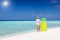 Holiday man standing a tropical paradise beach and holding a yellow floaty