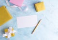 Holiday mockup: top fiew flat lay gold and pastel pink gift boxes with white ribbon, empty card and pencil on blue background. Gre Royalty Free Stock Photo