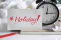 Holiday Note Put In Front Alarm Clock Royalty Free Stock Photo