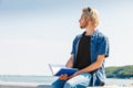 Sitting man reading book outside on sunny day Royalty Free Stock Photo