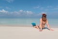 Picture from back of a young woman with flippers and mask seated on a white beach in the Maldives. Crystal clear blue water as Royalty Free Stock Photo