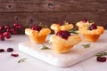 Holiday puff pastry appetizers with cranberries and baked brie, side view platter