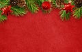 Holiday red background with Christmas tree twigs, cones, balls Royalty Free Stock Photo