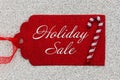 Holiday Sale message on red gift tag with a candy cane