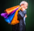 Holiday sales. An elderly man with many shopping bags in his han Royalty Free Stock Photo