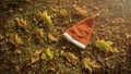 Holiday season is coming soon. A conceptual background photo of Santa Claus hat on yellow leaves in fall. Last day of autumn and