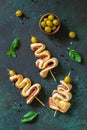 Holiday snack puff dough Christmas tree with olive and bacon on a slate or stone tabletop.