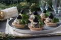 Holiday snack in tartlets with mushrooms, egg and black olives on a gray background Royalty Free Stock Photo