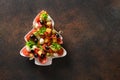 Holiday snacks as canapes in shape of Christmas tree plate for festive Xmas party.
