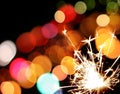 Holiday sparkler and colorful lights Royalty Free Stock Photo