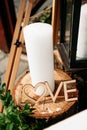 The word Love carved from wood, a white candle, standing on a wooden stump