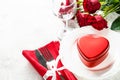 Holiday table setting with plate, roses and red heart. Royalty Free Stock Photo