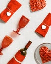 Holiday table setting for Valentines Day, pattern with red colored wine glasses, plates decorated hearts, bottle of wine