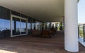 Holiday tables, chairs, a sofa and closed umbrellas on the porch Royalty Free Stock Photo