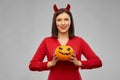 Woman in halloween costume of devil with pumpkin Royalty Free Stock Photo