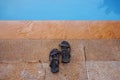 Holiday time. Sandal beside the swimming pool Royalty Free Stock Photo