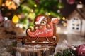 Holiday traditional food bakery. Gingerbread christmas bear in sleigh in cozy decoration with garland lights