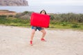 Holiday, travel and tourism concept - young woman with red suitcase over sea background Royalty Free Stock Photo