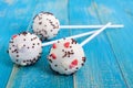 Holiday treats. Cake pops. Biscuit cakes in white chocolate glaze on a bright blue wooden background Royalty Free Stock Photo