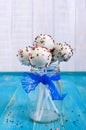 Holiday treats. Cake pops. Biscuit cakes in white chocolate glaze on a bright blue wooden background. Royalty Free Stock Photo