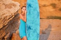 Holiday trip, beach day and summer time idea, copy space. Attractive girl posing with surfboard on blue sky background. Royalty Free Stock Photo