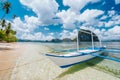 Holiday vacation scene of tropical sandy beach with island hopping boat. Blue sky with white clouds Royalty Free Stock Photo