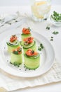 Holiday vegetable appetizers. Cucumbers rolls with soft cheese, pieces of salted salmon, microgreens and black sesame served on a Royalty Free Stock Photo
