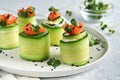 Holiday vegetable appetizers. Cucumbers rolls with soft cheese, pieces of salted salmon, microgreens and black sesame served on a Royalty Free Stock Photo