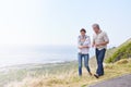 Holiday, walk and mature couple on road at the beach in countryside or nature with conversation of retirement. Summer Royalty Free Stock Photo