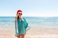 Holiday woman in santa hat relaxing on paradise beach. Christmas vacation. copy space Royalty Free Stock Photo