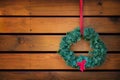 Holiday wreath hanging against wood planks