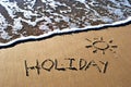 Holiday written in sand