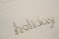 `Holiday` written in the sand on the beach Royalty Free Stock Photo