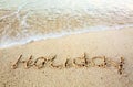 Holiday Written in sand at the beach. Royalty Free Stock Photo