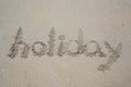 `Holiday` written in the sand on the beach Royalty Free Stock Photo