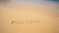 Holiday written in the sand at the beach waves in the background Royalty Free Stock Photo