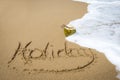 Holiday written in sand on a beach. Royalty Free Stock Photo