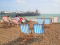 Holidaymakers and deckchairs on pebble beach