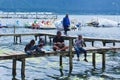 Holidaymakers Are Fishing On A Simple Pier In The Mountain Lake Tourism Area Of Beratan