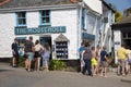 Holidaymakers mingle outside a shop in Mousehole, Cornwall, UK