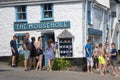 Holidaymakers mingle outside a shop in Mousehole, Cornwall, UK