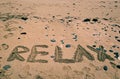 Holidays background with RELAX word written on sandy beach. Holidays background. Summer. In relax mood Royalty Free Stock Photo